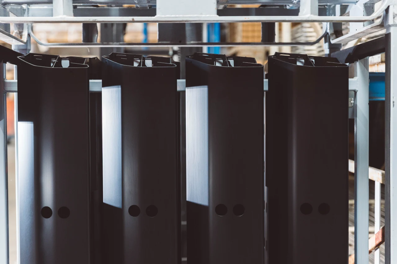Schwarz behandelte Aluminiumbauteile auf Warenträgern