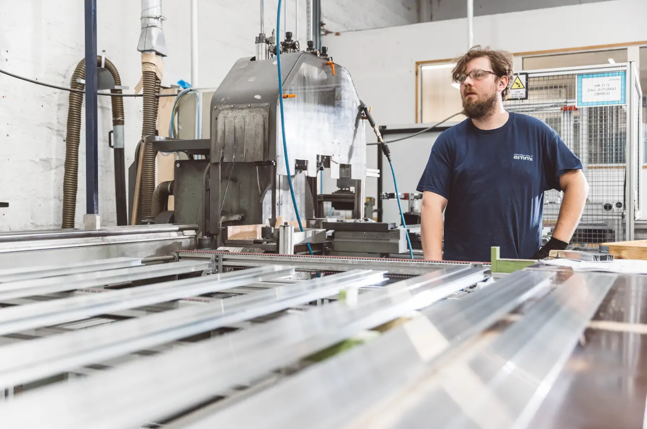 Mitarbeiter an einer Maschine zur Bearbeitung von Aluminiumprofilen
